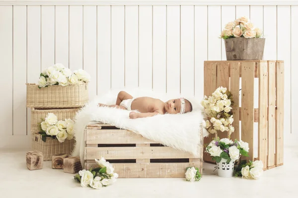 Adorável bebê menina deitada na caixa de madeira com cobertor de pele — Fotografia de Stock