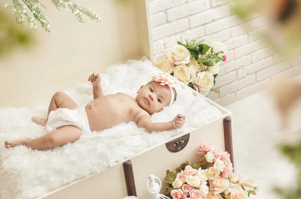 Vrolijke babymeisje voelen liggend op krat met bont blan — Stockfoto