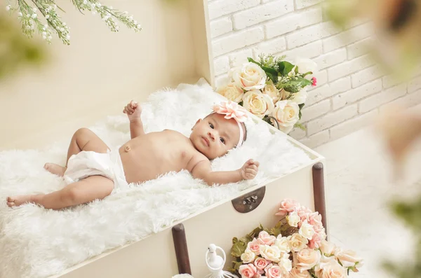 Cheerful baby girl feel comfortable lying on crate with fur blan — Stock Photo, Image