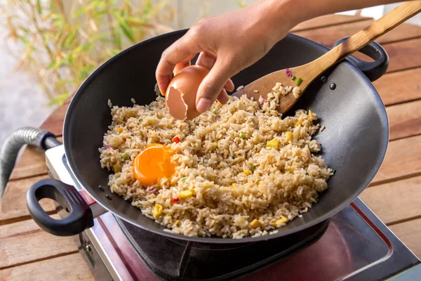 Людські руки додають яйце в смажений рис — стокове фото