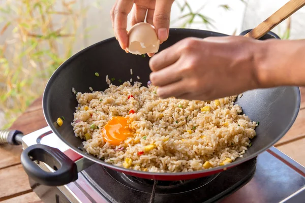 Людські руки додають яйце в смажений рис — стокове фото