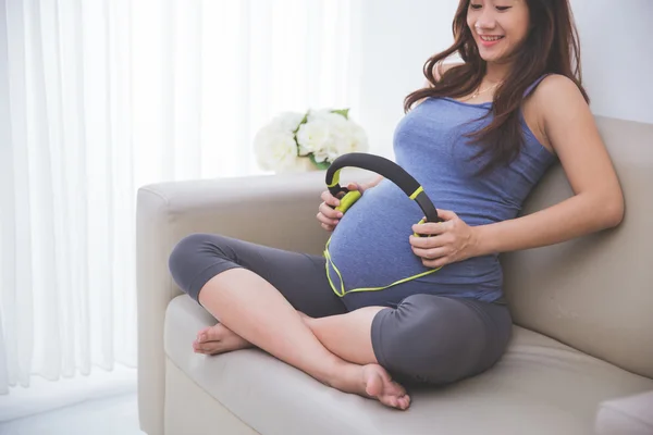 Embarazada asiático mujer usando auriculares — Foto de Stock