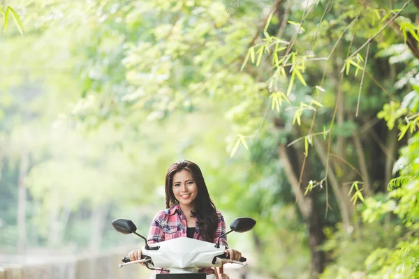 Joven mujer asiática montando una motocicleta — Foto de Stock