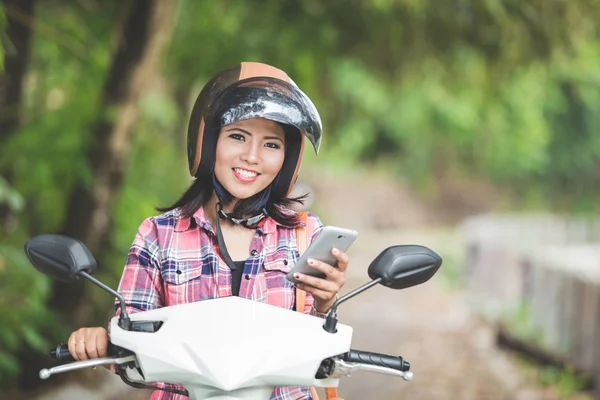 年轻的亚裔女子，骑一辆摩托车 — 图库照片