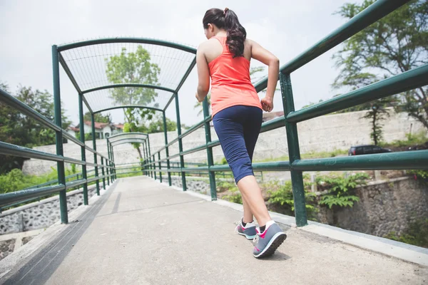Junge asiatische Frau joggt im Park — Stockfoto