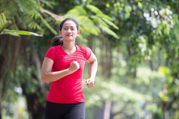 Jonge Aziatische vrouw joggen in het park — Stockfoto
