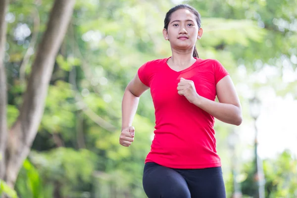 Jonge Aziatische vrouw joggen in het park — Stockfoto