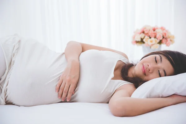 Беременная азиатка мирно спит — стоковое фото