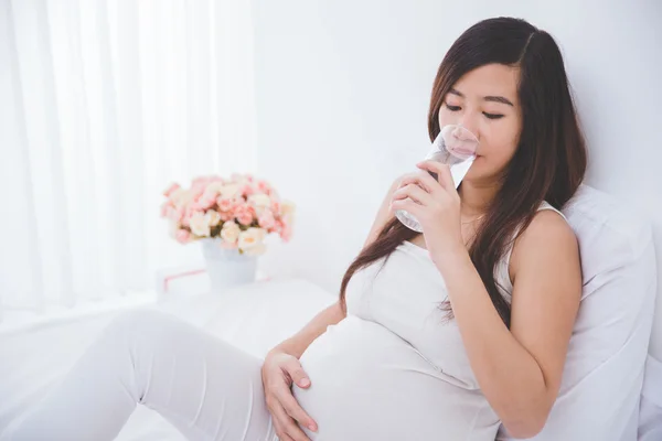 Pregnant asian woman with glass of water — Stock Photo, Image