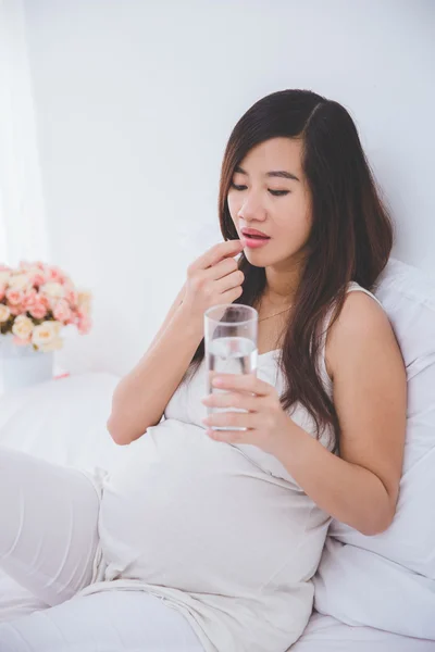 Pregnant asian woman with glass of water — Stock Photo, Image