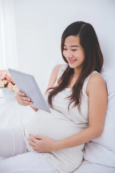 Těhotná žena držení počítače tablet pc — Stock fotografie