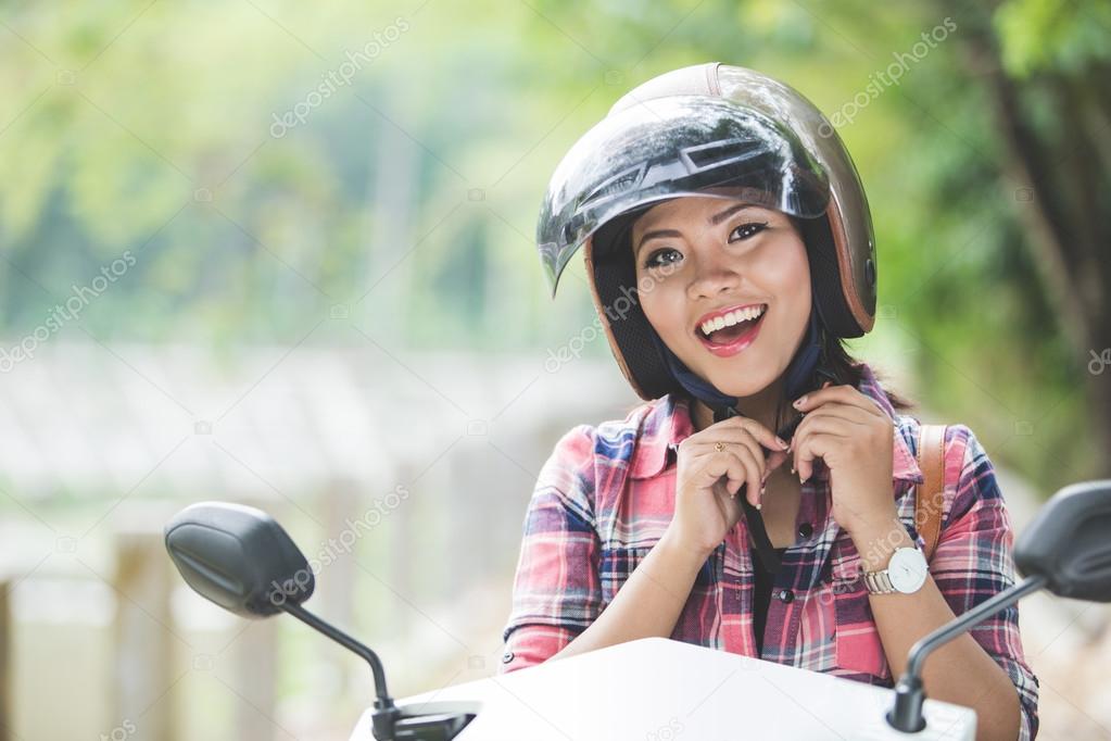 Young Asian woman riding a motorcycle