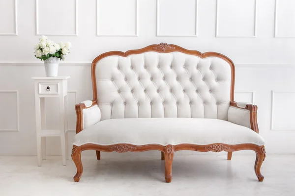 Styl vintage biały sofa z wazon z kwiatami na biurko — Zdjęcie stockowe