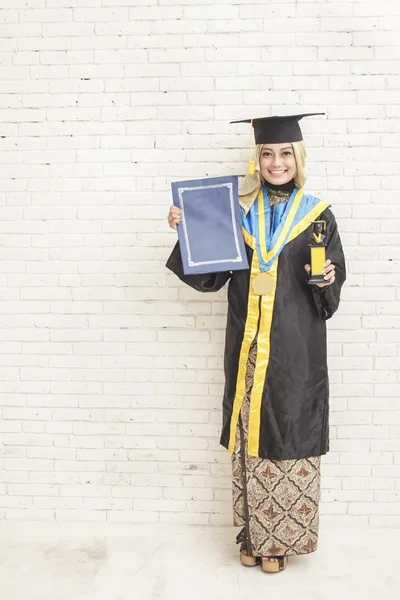 Ινδονησιακά-θηλυκό μεταπτυχιακός φοιτητής φορώντας αποφοίτηση εσθήτα whil — Φωτογραφία Αρχείου