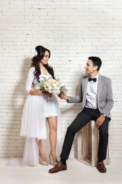 Mooie bruid en knappe bruidegom staren elkaar — Stockfoto