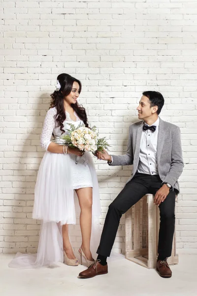 Beautiful bride and handsome groom staring each other — Stock Photo, Image