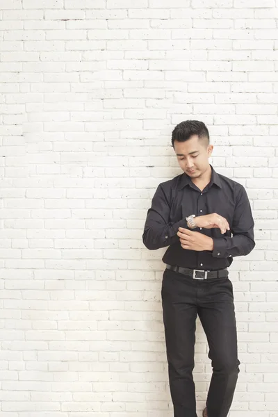 Casual asiático homem de pé enquanto fixa sua camisa manga — Fotografia de Stock