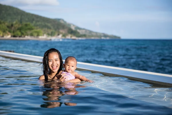 Bebê se divertindo na piscina com a mãe — Fotografia de Stock