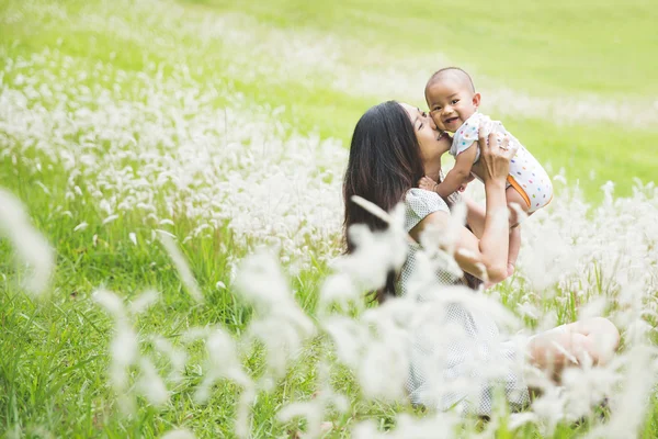 Mãe e seu bebê se divertindo juntos ao ar livre — Fotografia de Stock