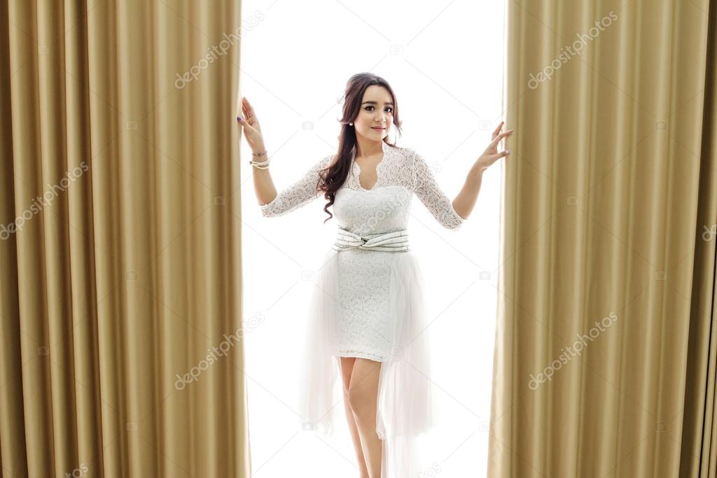 beautiful bride posing between curtain