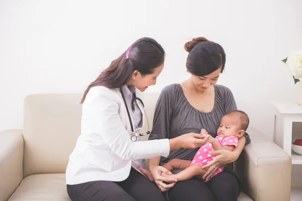 Asyalı kadın çocuk doktoru muayene bebek — Stok fotoğraf