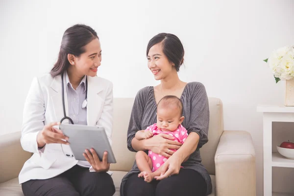 Asiatiska kvinnlig barnläkare undersökande baby — Stockfoto