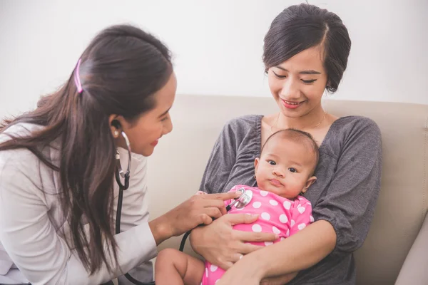 Asiatiska kvinnlig barnläkare undersökande baby — Stockfoto