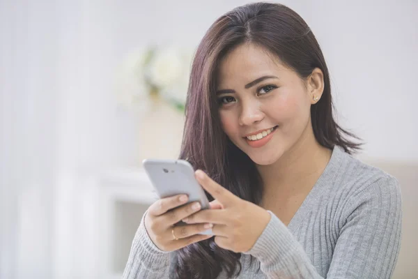 Asian female at home using phone — Stock Photo, Image