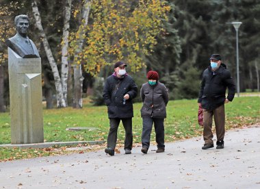 Unrecognizable senior people with face masks for protection from coronavirus are walking in the park in Sofia, Bulgaria on November 22, 2020 . Elderly people with protective masks are walking on a fresh air, before quarantine.