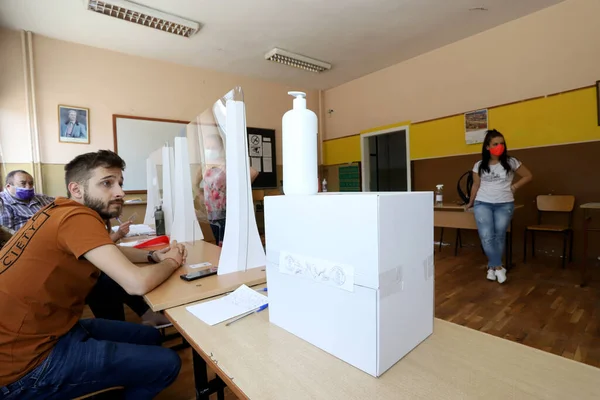 2021年7月11日ブルガリアのソフィアで開催されたブルガリア議会選挙では マスクを持つ人々が投票機を使用しています — ストック写真