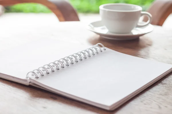 Otevřené prázdné bílé notebook s šálkem kávy — Stock fotografie