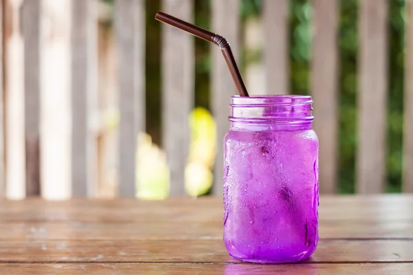 Iced drink in violet glass in coffee shop — Stock Photo, Image