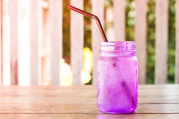 Iced drink in violet glass in coffee shop — Stock Photo, Image