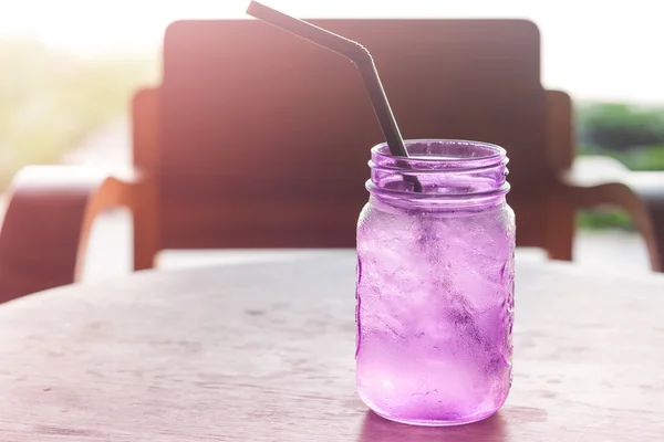 Iced drink in violet glass in coffee shop — Stock Photo, Image