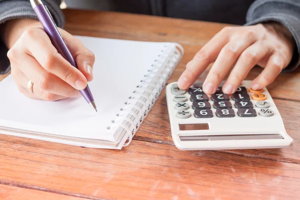 Ręka kobiety z piórem, pisanie na notebooka — Zdjęcie stockowe