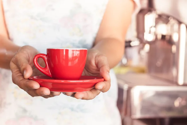 Woman's hand holding red coffee cup — Stock Photo, Image