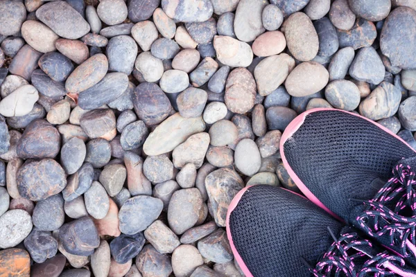 Zapatillas de correr en casa jardín sobre guijarros —  Fotos de Stock