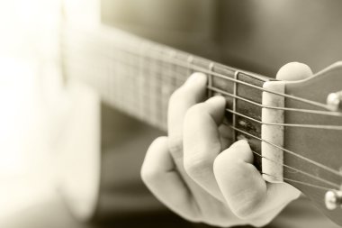 Kadının akustik gitar çalmak vintage filtresiyle eller.