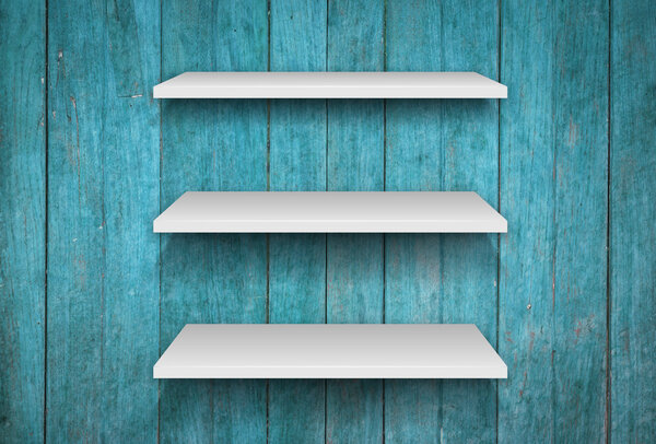 Три белые полки на синем деревянном фоне интерьера
