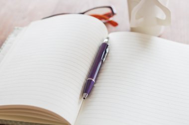 Kalem ve defter ahşap masada.
