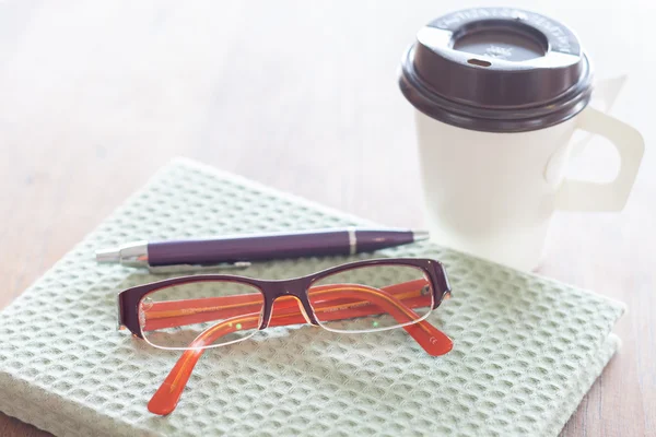 Bärbara datorer, penna glasögon och kaffekopp på träbord — Stockfoto