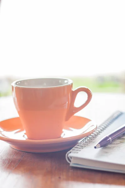 Cup of coffee with pen and notebook — Stock Photo, Image