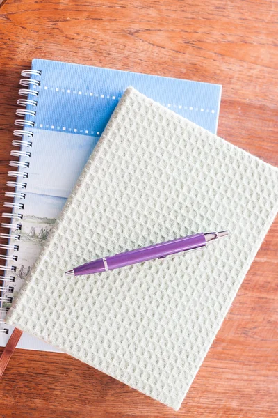 Pluma y dos de cuadernos sobre mesa de madera —  Fotos de Stock