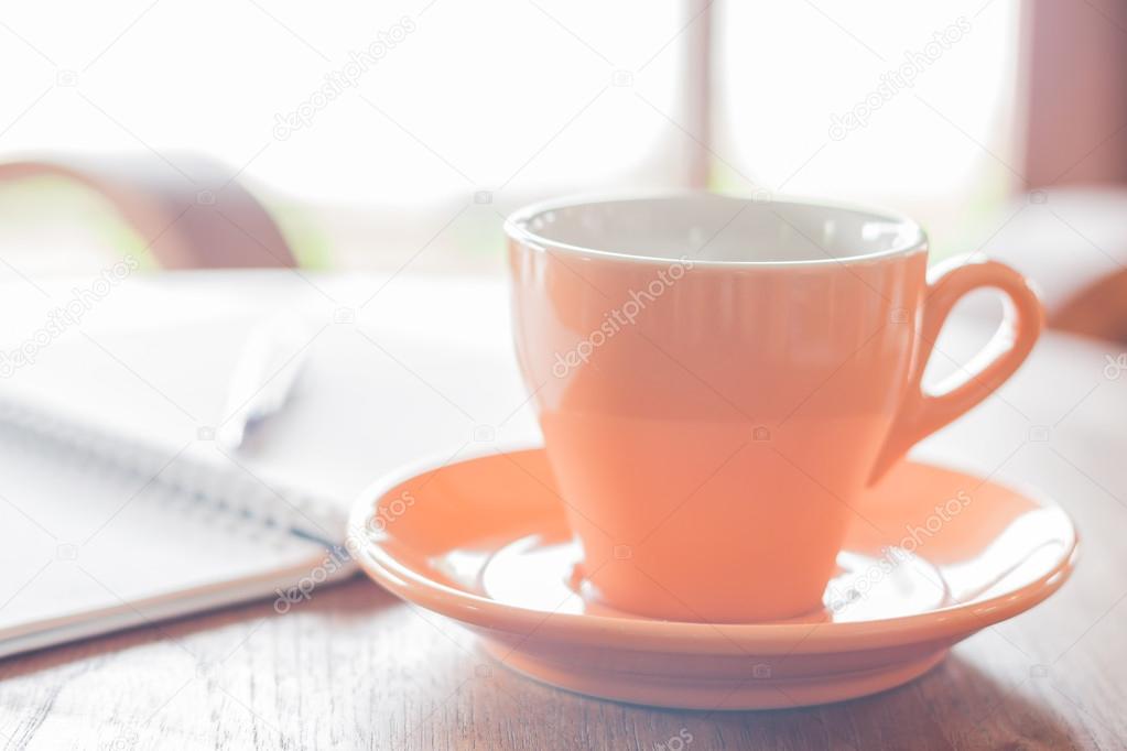 Closeup orange coffee cup in coffee shop