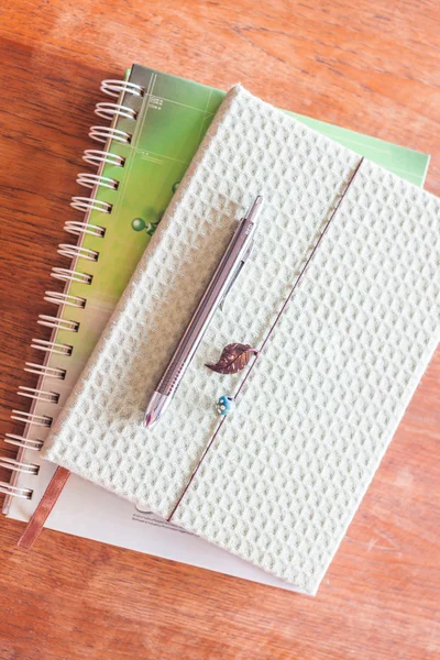 Top view of pen on two notebooks on wooden table — Stock Photo, Image