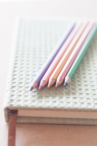 Closeup color pencils on green notebook — Stock Photo, Image