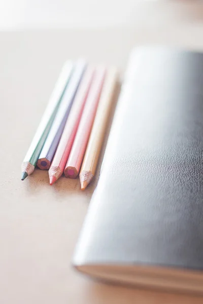Crayons de couleur avec carnet noir — Photo