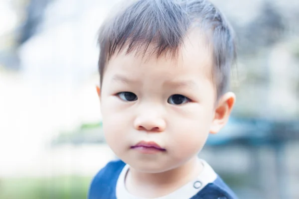 Liten asiatisk pojke tittar på kameran — Stockfoto