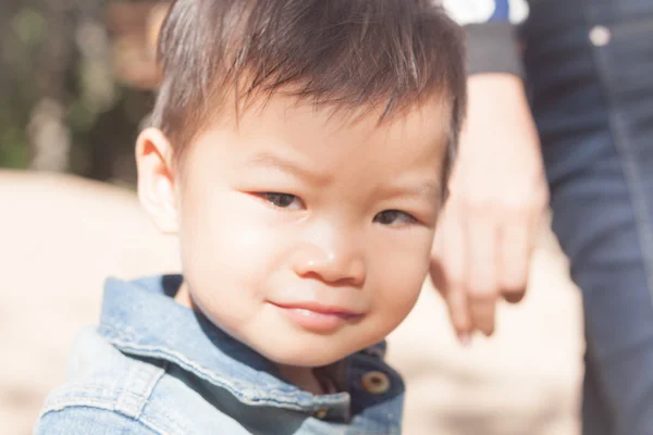 Liten asiatisk pojke tittar på kameran — Stockfoto