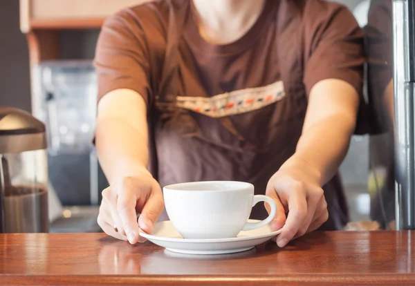Barista offering white cup of coffee — Stock Photo, Image